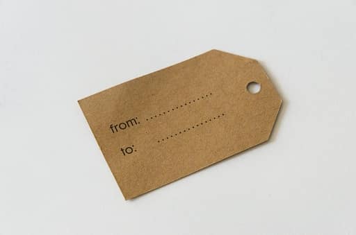 Twenty-two raw kraft chipboard shapes including two photo frames, luggage tags, arrows and numbered circles, with one frame inked around the edges in brown